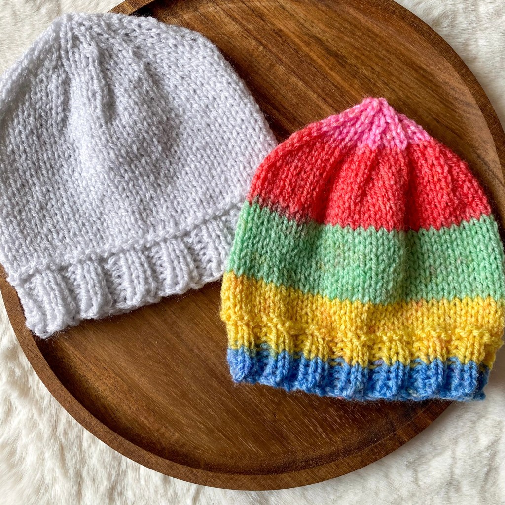 Two hand knit beanie hats for newborn babies